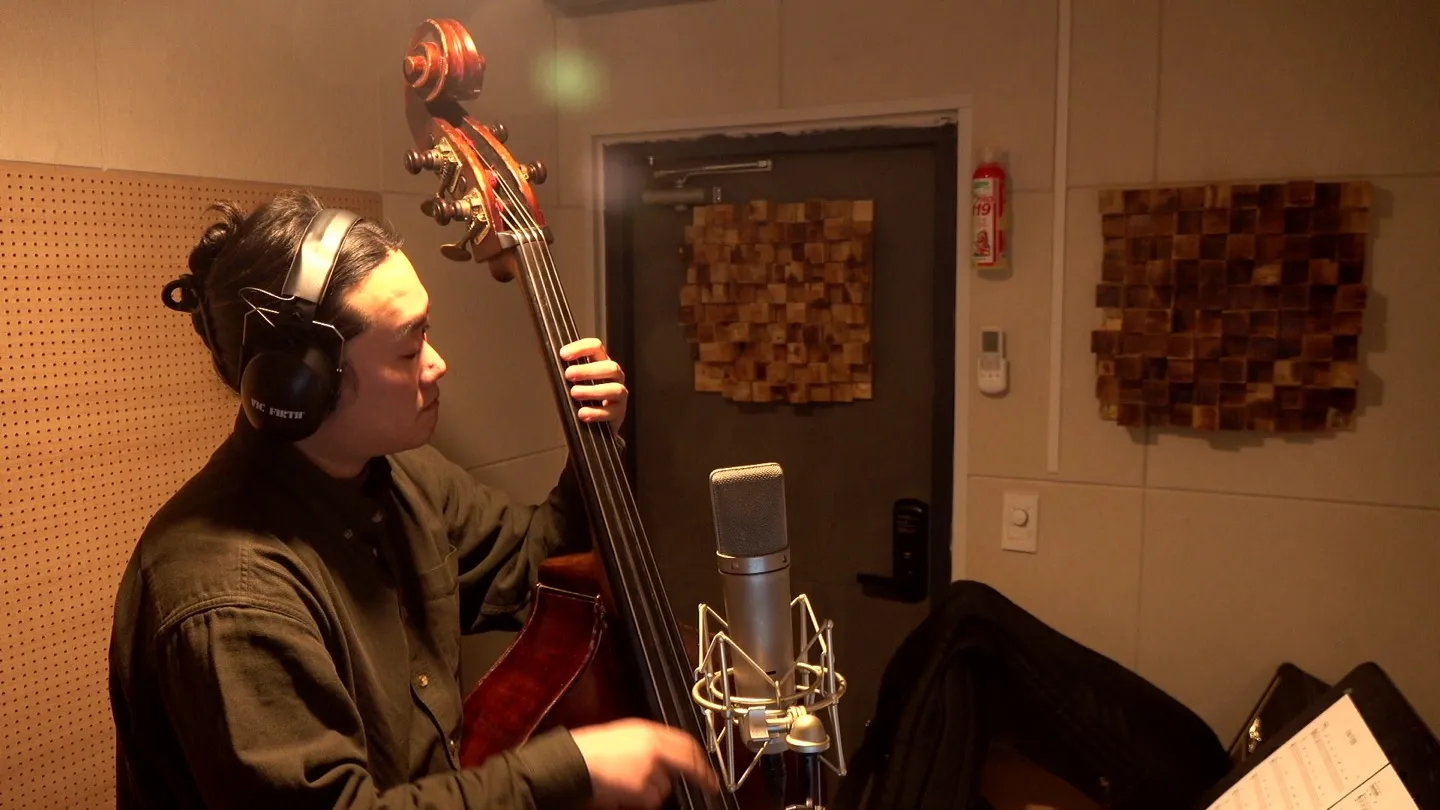 Upright bass recording session in studio booth